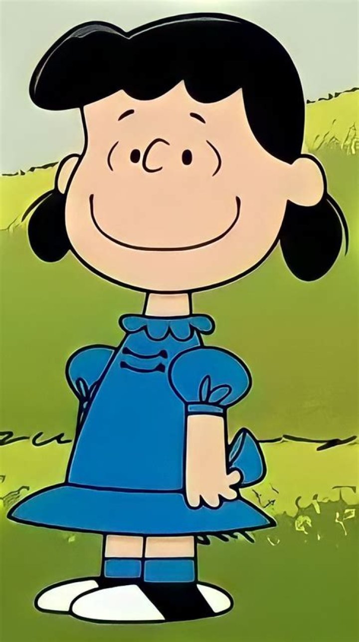 Lucy in a orange top standing next to Happy